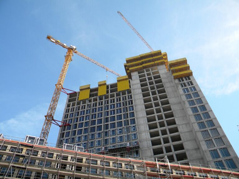 Cranes beside a high rise building under construction