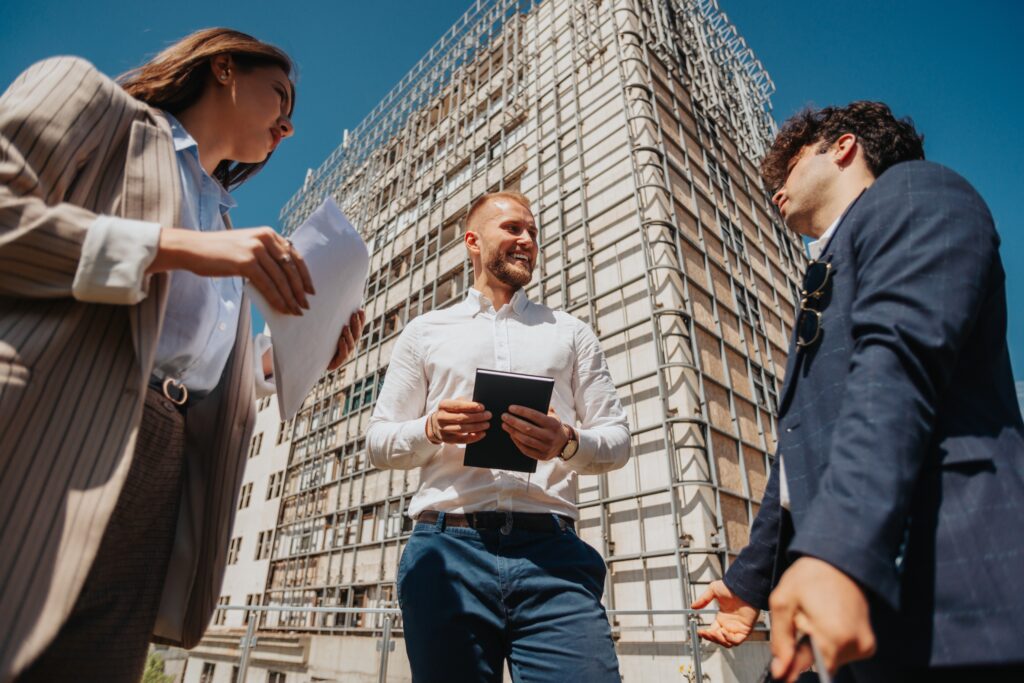 Stakeholders discussing outside building under construction.