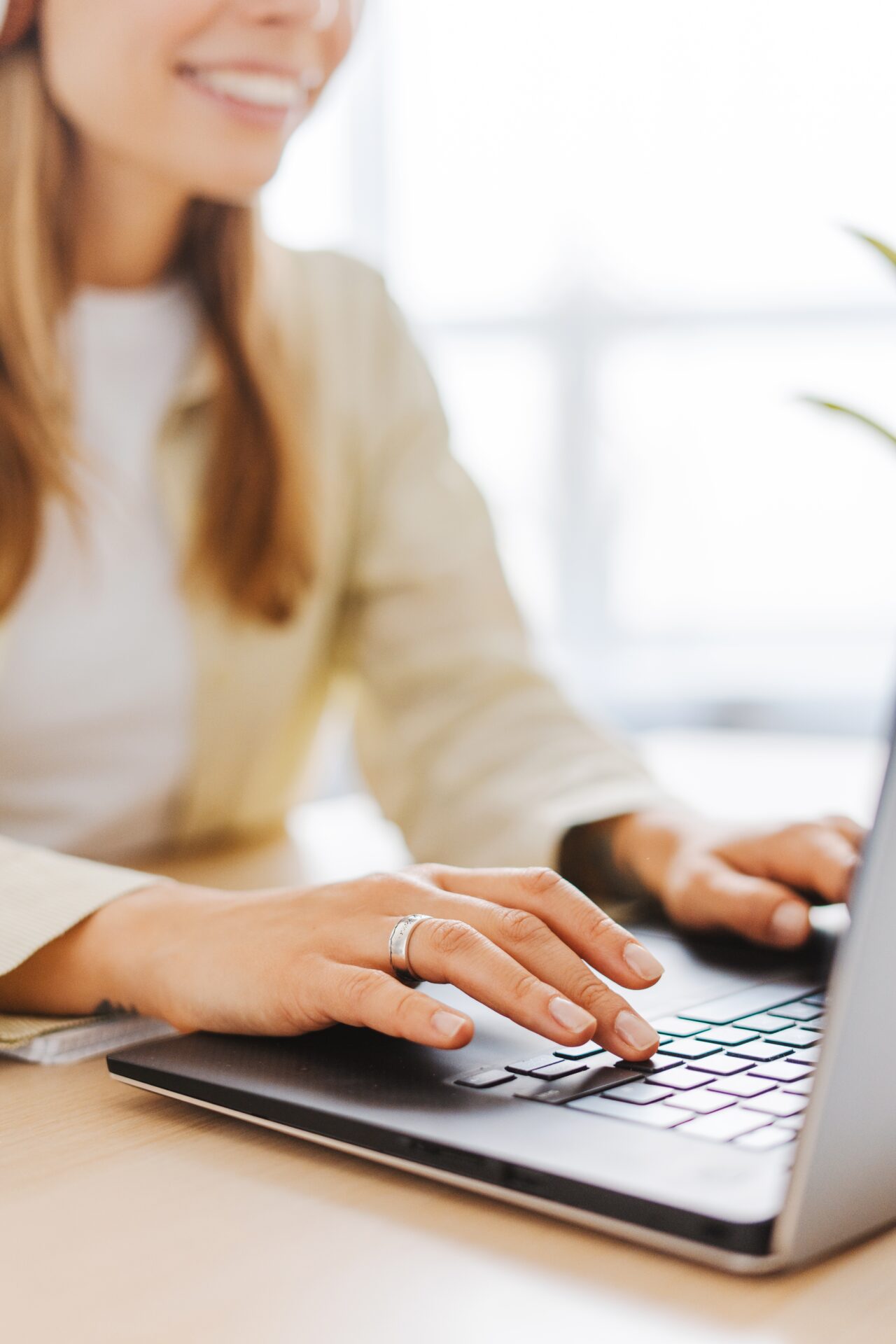Young woman happily working from home on her laptop