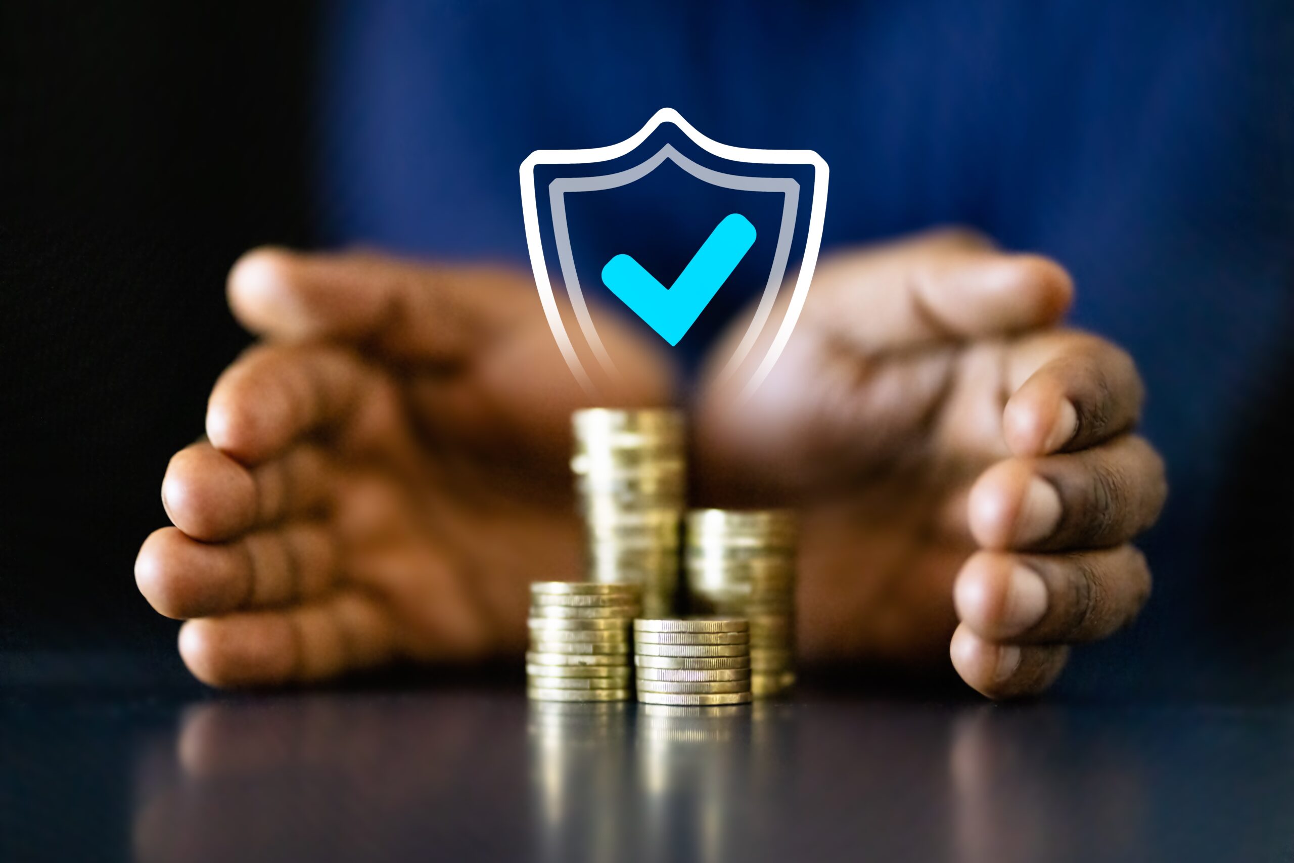 Hands protecting a pile of coins with a digital shield.