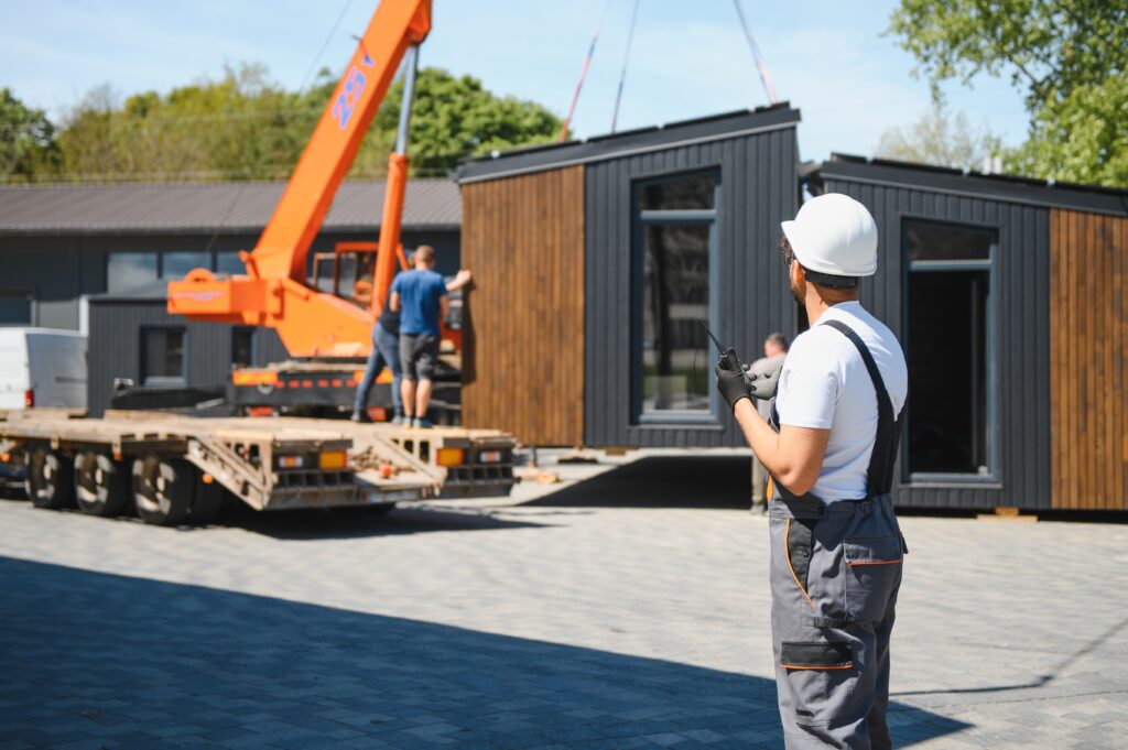 Engineer oversees a prefabricated house being placed.