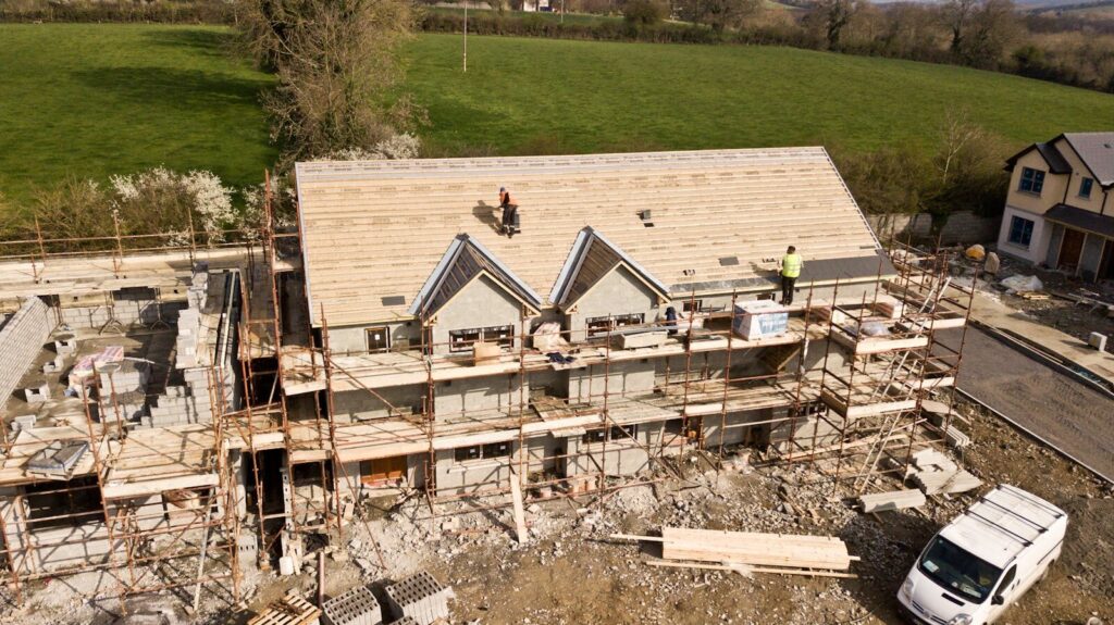 Aerial shot of a house under construction. Workers on the roof.