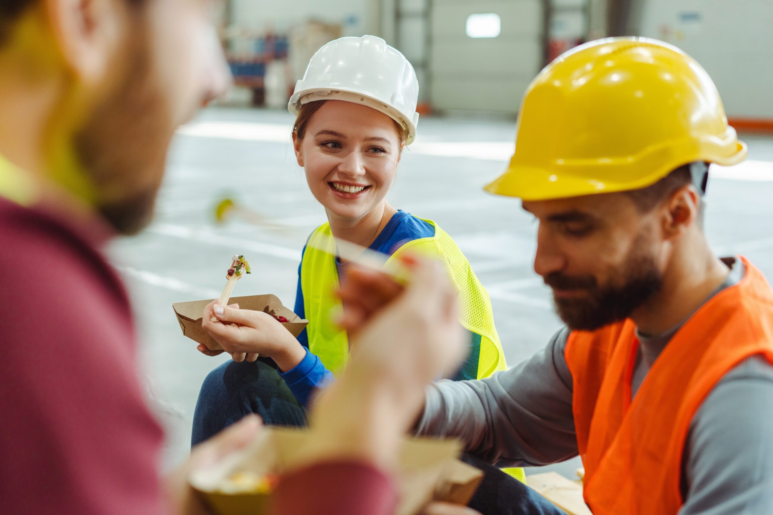 Group of happy builders eating lunch together