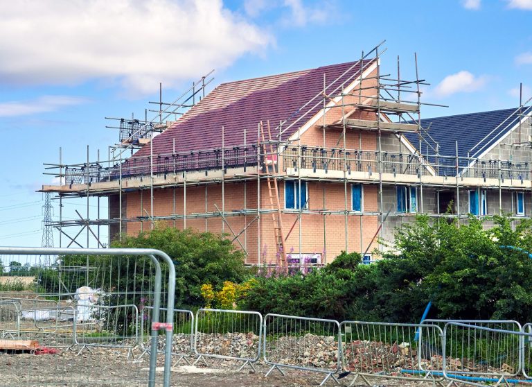 Image of new houses being built, structure nearly complete but still under construction.